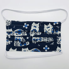 Load image into Gallery viewer, Made with three layers of white cat designs on blue print 100% quilting cotton, this mask includes a filter pocket located in the pleats in the back of the mask for a filter of your choice, elastic head bands and a bendable aluminum nose. Machine wash and dry after each use. 7” H x 7.5” W
