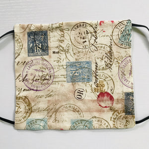 100% quilting-weight 100% cotton face mask with elastic bands and bendable nose piece. The novelty, tan print give the mask an antique feel. Wash in washing machine and dry in dryer after each use.  Collection: Correspondence - Stamps and Postmarks Fabric, Eclectic Elements by Tim Holtz  7” H x 7.5” W