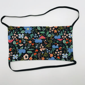 Made with three layers of 100% quilting-weigh cotton with the Rifle Paper Co Wild Roses on black print. This mask includes a filter pocket located in the pleats in the back of the mask for a filter of your choice and comes with elastic head bands and a bendable aluminum nose piece. Machine wash and dry after each use. 7” H x 7.5” W