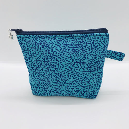 The small pouch is made from 100% blue/teal vine maze print and has a layer of fleece for structure and a cute metal tassel. The pouch design is from the Becca Bags pattern from Lazy Girl Design. 6”W x 4.5” H x 1”D. Machine washable and dryer safe or air dry.