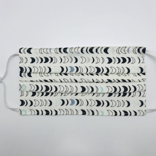 Masks are made of 2 layers 100% quilting cotton featuring blue, white and black half moons in rows on white print, adjustable elastic ear loops and a bendable aluminum nose. Wash in washing machine and dry in dryer after each use. 7” H x 7.5” W