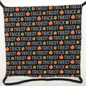 Image of Trick or Treat works and pumpkins on black fabric print.