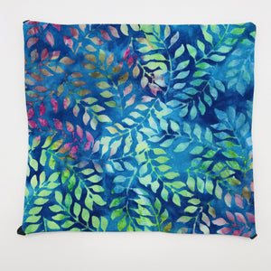 Image of blue, green and purple leaves on a cotton batik fabric. 