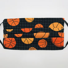 Load image into Gallery viewer, Made with three layers of basketballs on black print 100% quilting cotton, this mask includes a filter pocket located in the pleats in the back of the mask for a filter of your choice, adjustable elastic ear loops and a bendable aluminum nose. Machine wash and dry after each use. 7” H x 7.5” W
