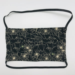 Made with three layers a spider webs on black print 100% quilting cotton, this mask includes a filter pocket located in the pleats in the back of the mask for a filter of your choice, over the head elastic loops and a bendable aluminum nose. Machine wash and dry after each use. 7” H x 7.5” W