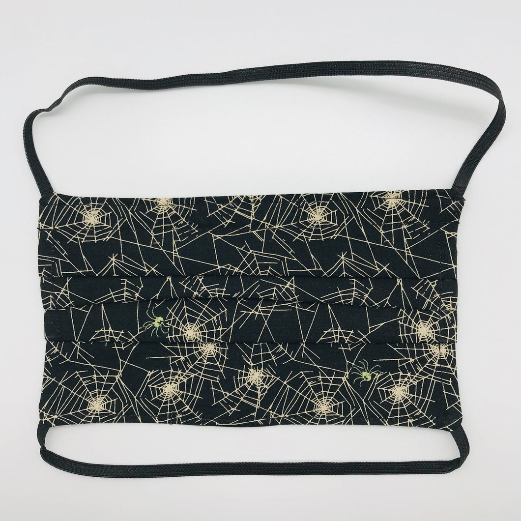 Masks are made of 2 layers 100% quilting cotton featuring a print of spider webs on black, over the head elastic loops and a bendable aluminum nose. Wash in washing machine and dry in dryer after each use. 7” H x 7.5” W 