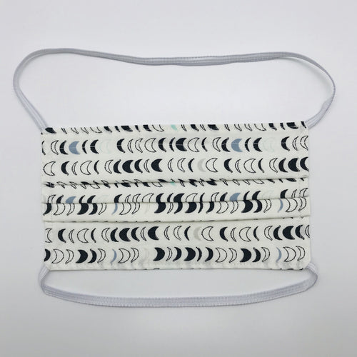 Masks are made of 2 layers 100% quilting cotton featuring blue, white and black half moons in rows on white background print, over the head elastic loops and a bendable aluminum nose. Wash in washing machine and dry in dryer after each use. 7” H x 7.5” W