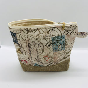 The pouch is made from 100% quilting cotton with tan antique stamp print, Kaufman Essex cotton/linen for the base, and a layer of fleece. The cute metal tassel gives an added touch. 7.5 W x 6”H x 2.5”D. Machine washable and dryer safe, or air dry.