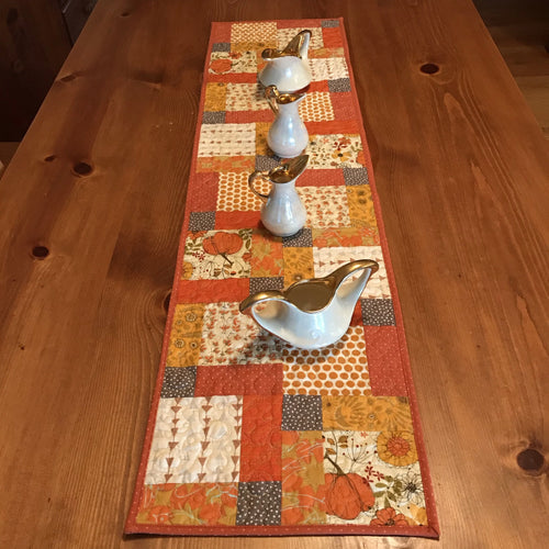 Beautiful fall colors table runner. 100% cotton, disappearing nine patch design. free-motion quilted in circular design. machine wash cold, line dry. 44
