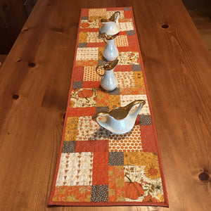 Beautiful fall colors table runner. 100% cotton, disappearing nine patch design. free-motion quilted in circular design. machine wash cold, line dry. 44" L x 11.5" W