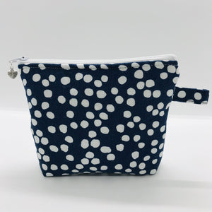 The pouch is made of 100% quilting cotton of a white dots on blue print and a layer of fleece for stability. The cute metal tassel gives an added touch. 6”W x 4.5” H x 1”D. Machine washable and dryer safe, or air dry.