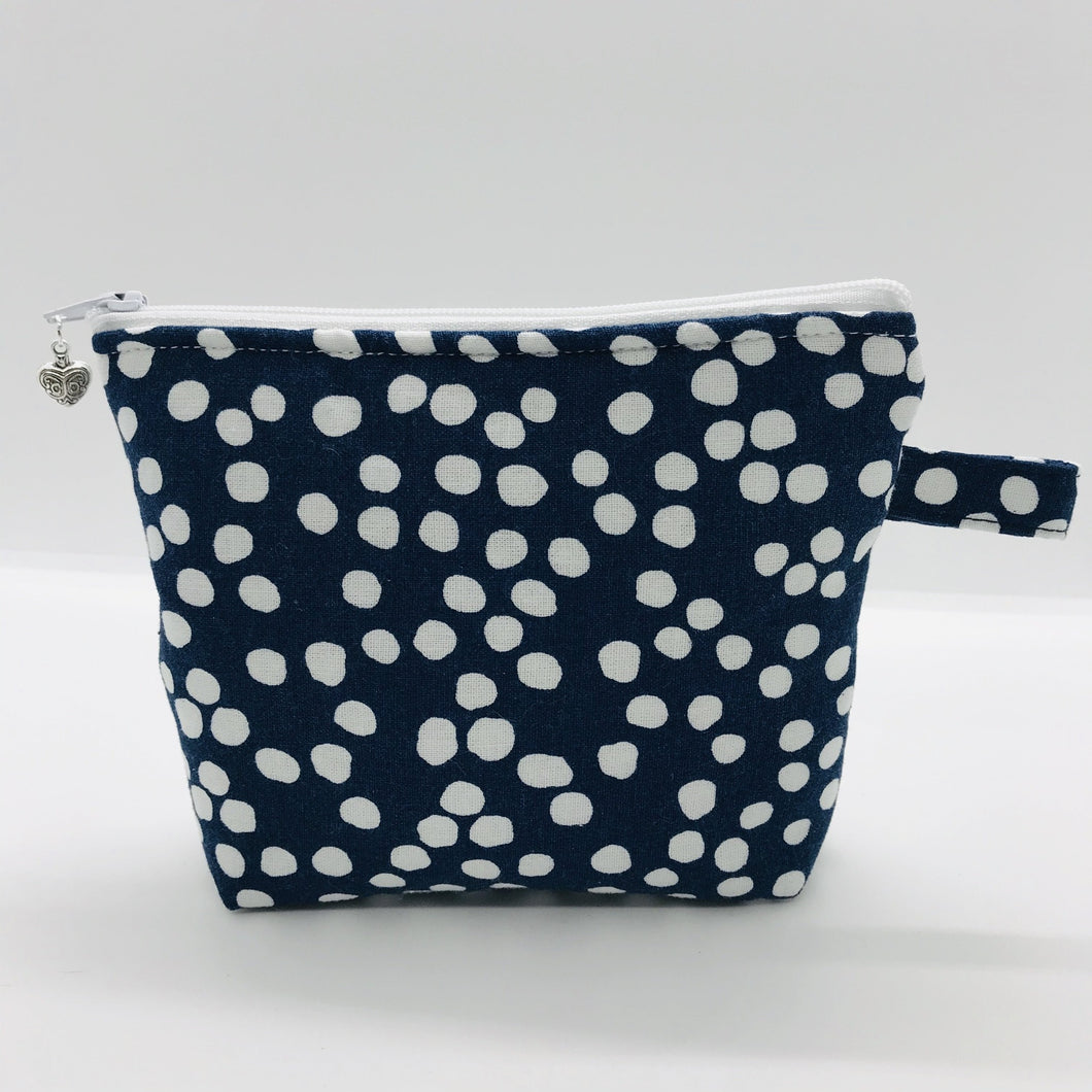 The pouch is made of 100% quilting cotton of a white dots on blue print and a layer of fleece for stability. The cute metal tassel gives an added touch. 6”W x 4.5” H x 1”D. Machine washable and dryer safe, or air dry.