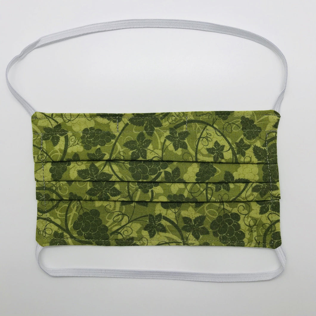 Masks are made of 2 layers 100% quilting cotton featuring a olive green grape leaves print, over the head elastic loops and a bendable aluminum nose. Wash in washing machine and dry in dryer after each use. 7” H x 7.5” W 