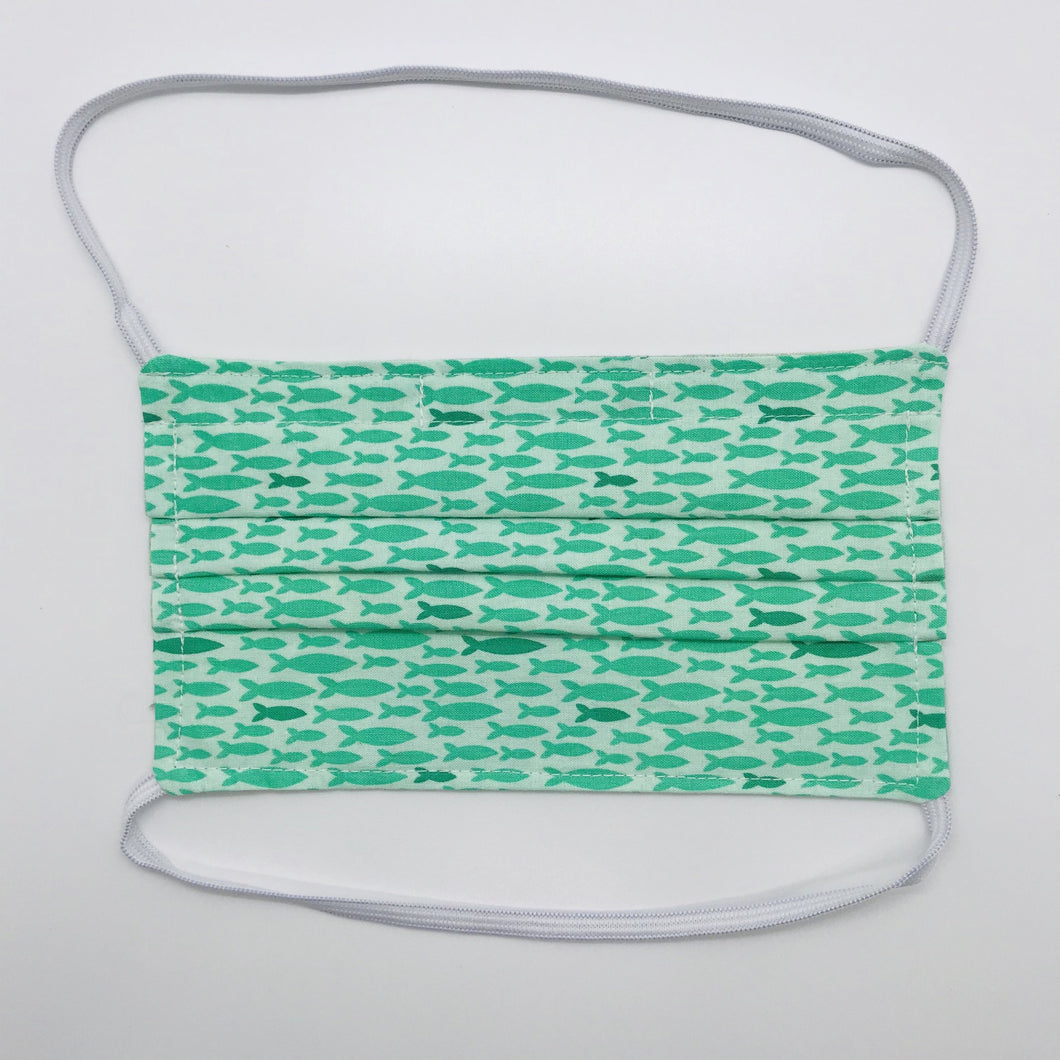 Masks are made of 2 layers 100% quilting cotton featuring a print of rows of aqua green fish, over the head elastic loops and a bendable aluminum nose. Wash in washing machine and dry in dryer after each use. 7” H x 7.5” W 
