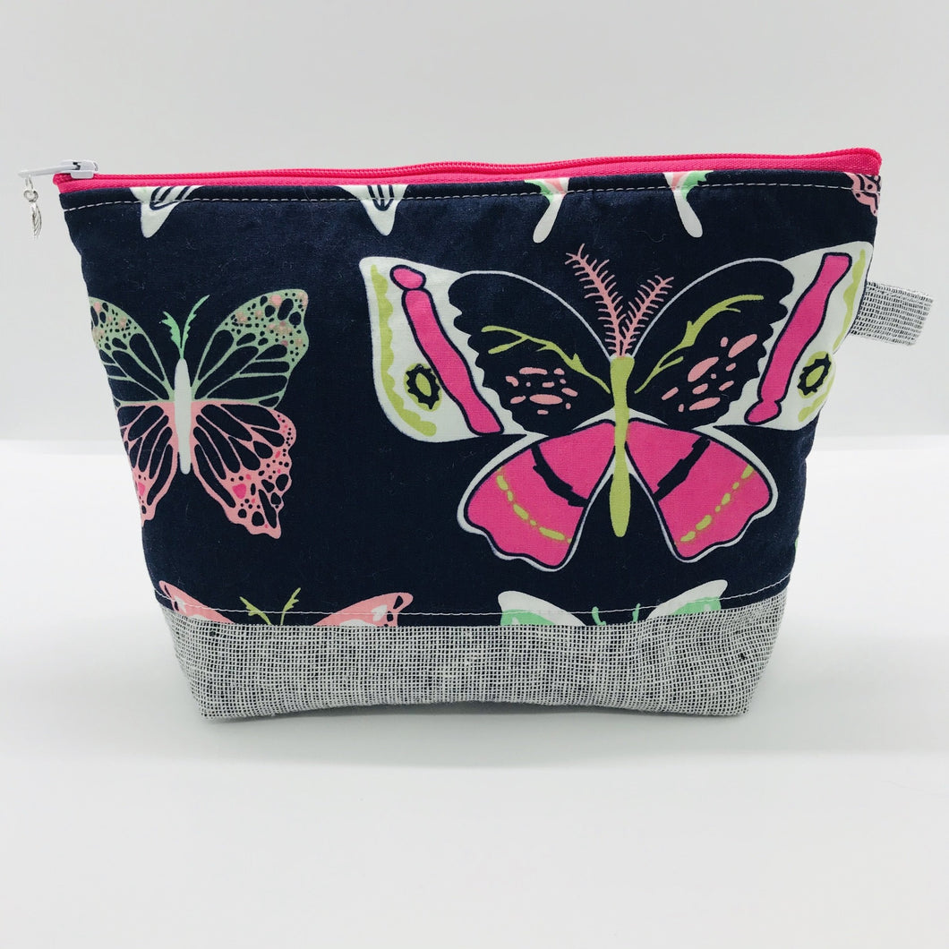 The pouch is made from 100% quilting cotton with a large pink and white butterflies on blue print by Art Gallery Fabrics, Kaufman Essex cotton/linen for the base, and a layer of fleece. The cute metal tassel gives an added touch. 7.5 W x 6”H x 2.5”D. Machine washable and dryer safe, or air dry.