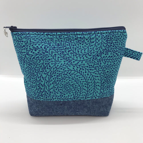 The pouch is made from 100% quilting cotton with a blue/teal vine maze print, Kaufman Essex cotton/linen for the base, and a layer of fleece. The cute metal tassel gives an added touch. 7.5 W x 6”H x 2.5”D. Machine washable and dryer safe, or air dry.