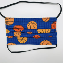 Load image into Gallery viewer, Made with three layers of basketballs on blue print 100% quilting cotton, this mask includes a filter pocket located in the pleats in the back of the mask for a filter of your choice, elastic head bands and a bendable aluminum nose. Machine wash and dry after each use. 7” H x 7.5” W
