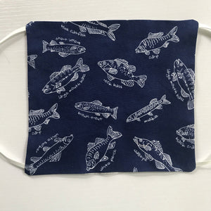 100% quilting-weight cotton blue background with white fish face mask with behind the head elastic bands  and bendable nose piece. Washable, reusable fabric face mask. Wash in washing machine and dry in dryer after each use. 7” H x 7.5” W