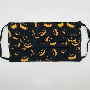 Masks are made of 2 layers 100% quilting cotton featuring a print of spooky orange faces on black, adjustable elastic ear loops and a bendable aluminum nose. Wash in washing machine and dry in dryer after each use. 7” H x 7.5” W