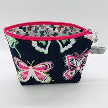 Load image into Gallery viewer,  The pouch is made of 100% quilting cotton from Art Gallery features a large pink and white butterflies on navy print and a layer of fleece for stability. The cute metal tassel gives an added touch. 6”W x 4.5” H x 1”D. Machine washable and dryer safe, or air dry.
